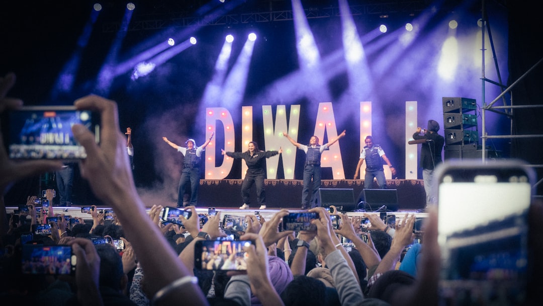 Concert crowd holding up smartphones at a live music event, Shazam-ing songs in real time